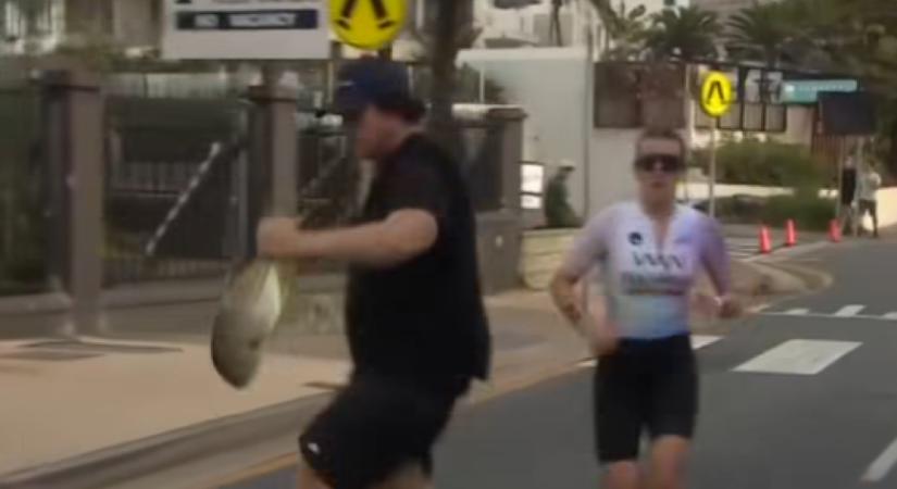 Itt mi történik? Hallal a kezében futott át egy férfi a triatlonversenyző előtt