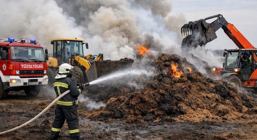 Munkagépekkel bontják a lángoló trágyát Buzsák külterületén