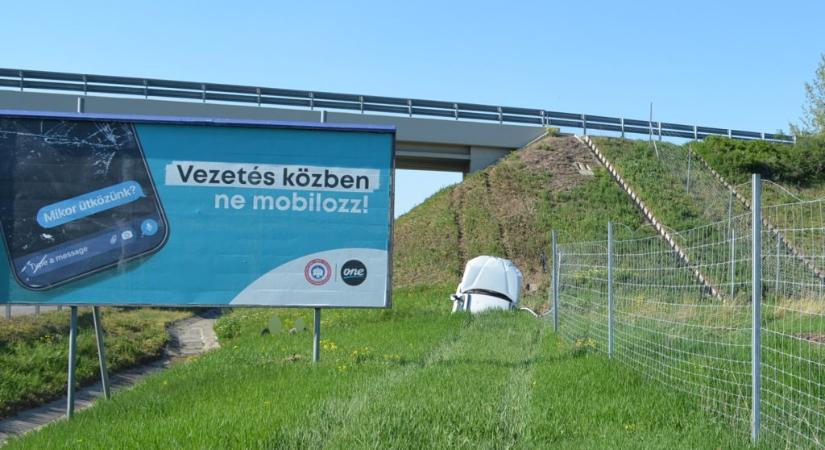 Földbe állt egy autó, a „vezetés közben ne mobilozz” tábla mellett