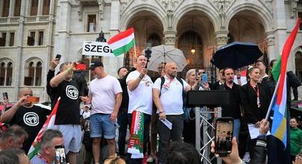 Magyar Péter integetve és zászlót lengetve fogadta az őt hazaárulózó tüntetőket