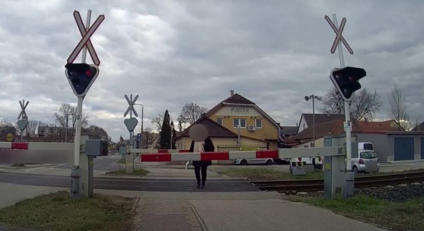 Hiába a tilos jelzés, a vonat előtt sétált át egy gyalogos a vasúti átjárón Győrben – videó
