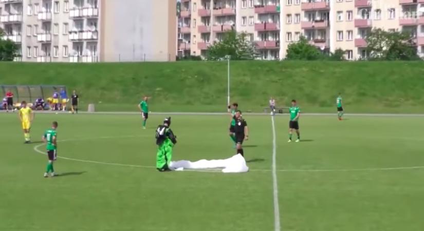 Sárga lapot kapott a focipályán földet érő ejtőernyős - videó
