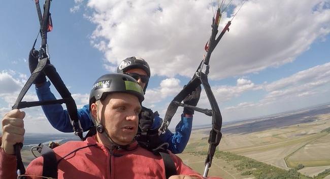 800 méter magasban szállt kollégánk – Bár munkatársunk arcára fagyott a mosoly, azért nagyon élvezte a siklóernyőzést