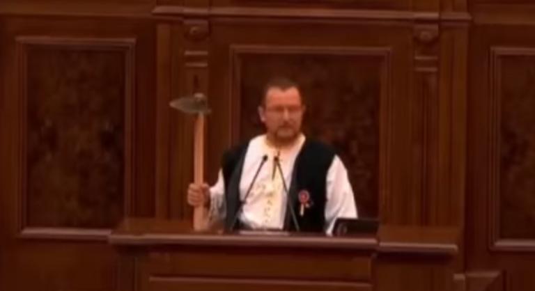 Videón, ahogy kapát lóbálva szólal fel a képviselő a parlamentben