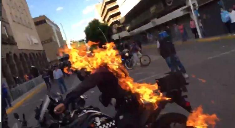 Felgyújtottak egy rendőrt a tüntetők (videó)