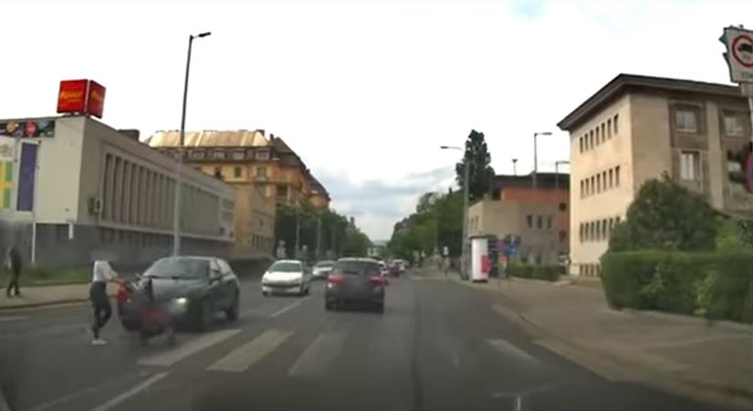 Megőrült: a száguldó autók között tolta át a babakocsit a nő – videó