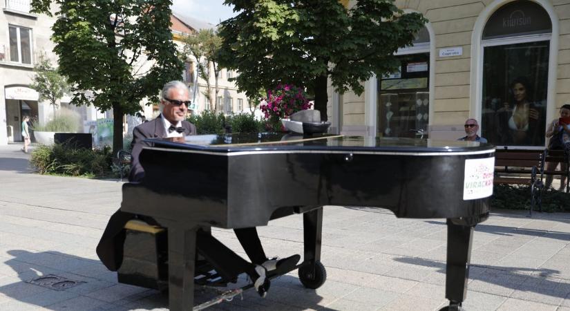 Guruló zongora és frakkot viselő zongorista Debrecen belvárosában