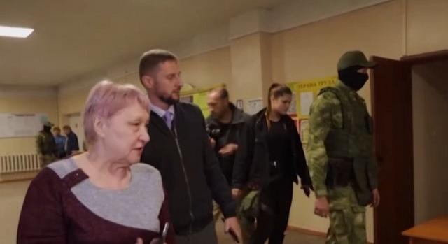 Fegyveres orosz katonák gyűjtik a megszállt ukrán területek lakóinak voksait a népszavazáson