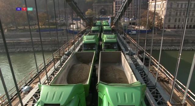 Videón, ahogy 24, egyenként húsztonnás teherautó dönget át a Lánchídon
