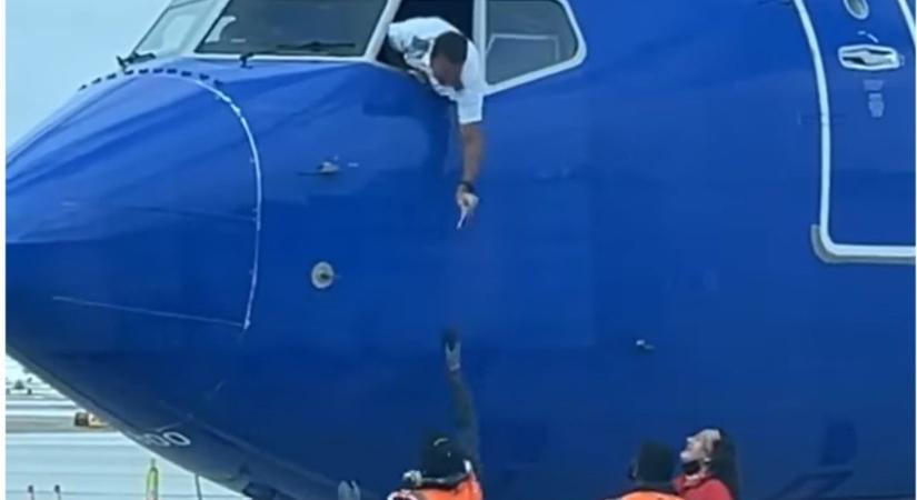 Elképesztő videó: a pilóta kihajolt a gépből, hogy átvegye az egyik utasa mobiltelefonját