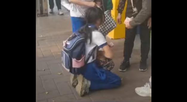 Videón: Térden állva kellett könyörögnie a diáklánynak a pénzéért az utcán egy nőnek