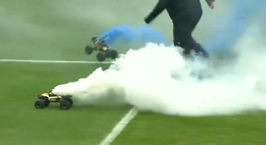 Videón, ahogy füstokádó kisautók lepik el a rostocki Ostseestadiont