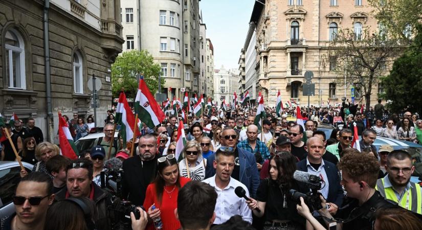 Partvisnyélre erősített magyar zászlókat osztanak a tömegben