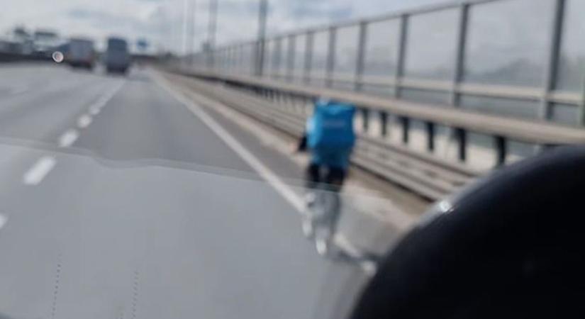 Nem akart kerülőt tenni az ételfutár, az M0-son biciklizve tette kockára az életét - videó