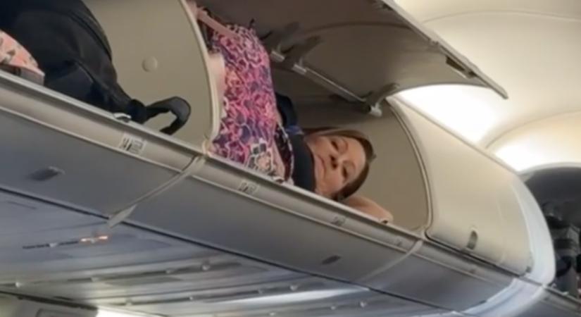 A repülőgép poggyásztartójában szunyókált egy nő – videó