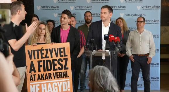 "Vitézyvel a Fidesz át akar verni" feliratú táblákkal vonult fel a Párbeszéd Vitézy Dávid sajtótájékoztatóján