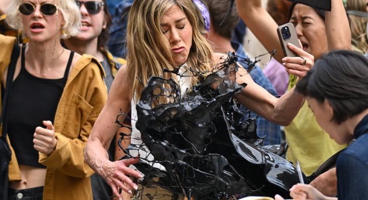 Lesifotókon, ahogy Jennifer Anistont izomból nyakon öntik egy nagy vödör fekete olajjal