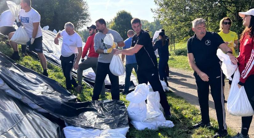 Kocsis Máté a kézilabdásokkal pakolja a homokzsákokat Vácon