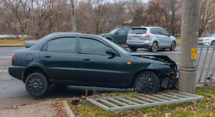 Baleset egy szolnoki cukrászdánál, törött autó hever egy lámpaoszlop tövében