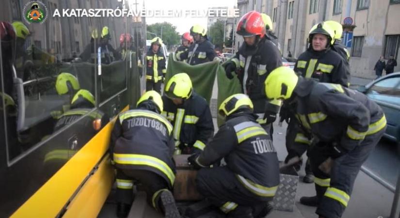 Videón, ahogy a gázolás után a tűzoltók kiemelnek egy embert a villamos alól Kőbányán