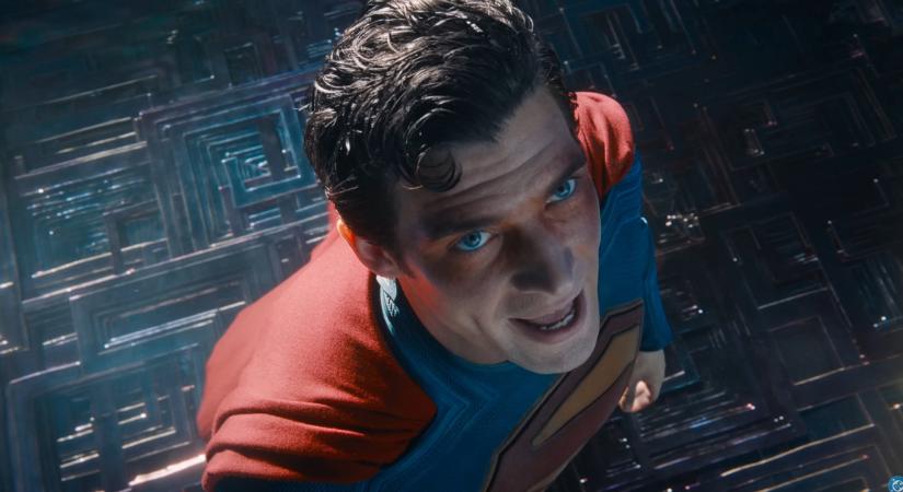 A megfáradt Superman kakaót iszik, miközben egy gigaszörny a háttérben tombol