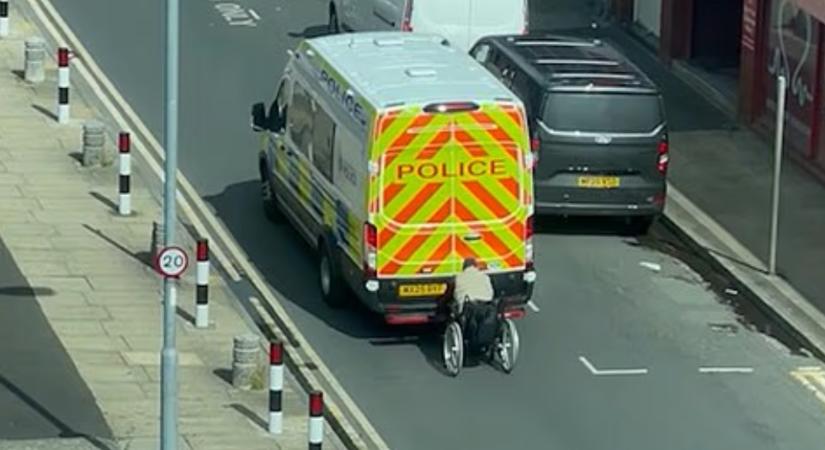 Videón, ahogy mozgó rendőrautóba kapaszkodik egy kerekesszékes Boltonban