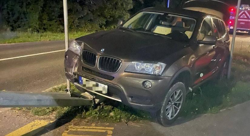Közlekedési táblák közé szorult egy BMW, az egyiket ki is döntötte