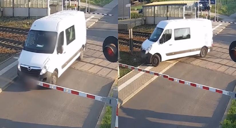 Videón, ahogy a sofőr megpróbálja kimanőverezni a furgonját a vasúti átjáróból