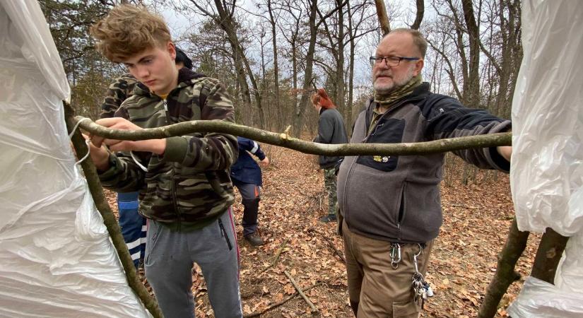 Feketébe borult az erdő mélyén álló kunyhó, titokzatos madárlest építenek a diákok – videóval
