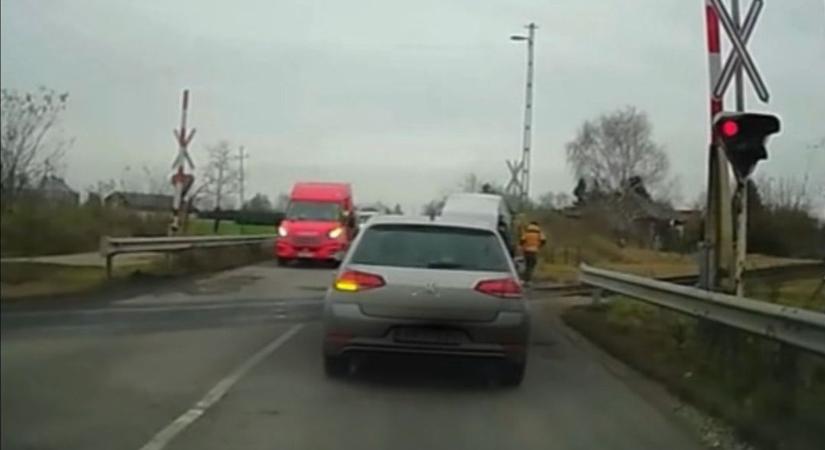 A piros jelzés alatt tolatott vissza elszabadult pótkocsijáért egy sofőr a vasúti átjáróban – videó