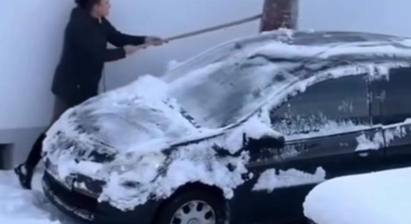 Csöndben sírt az autó, ahogy egy magyar hölgy takarította róla a havat