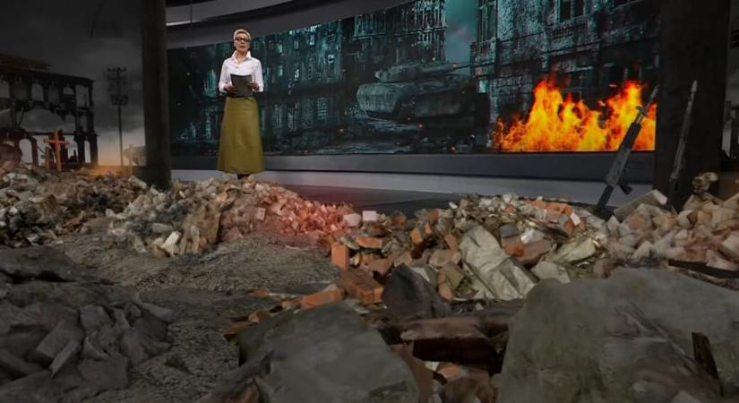 Lángokkal, törmelékkel és fegyverekkel berendezett stúdióból jelentkezik az állami tévé új, háborús műsora