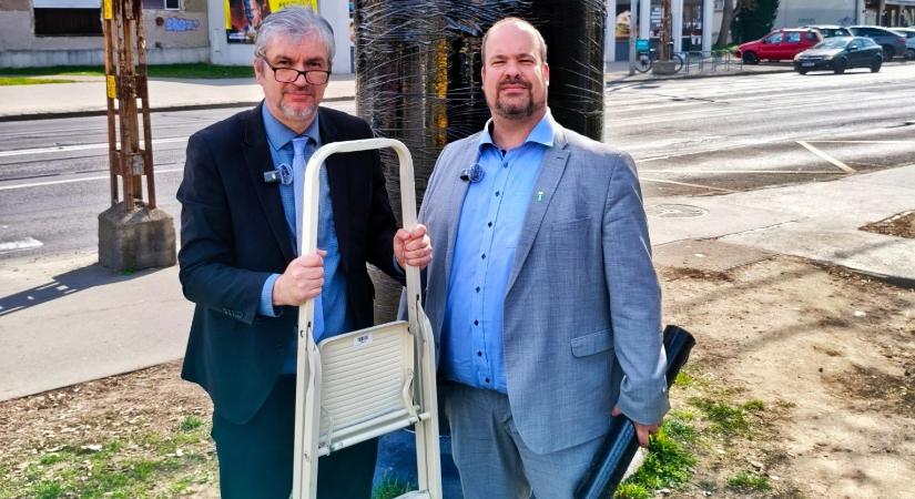 Videón, ahogy Hadházy Ákos és a zuglói polgármester lefóliáz egy hirdetőoszlopot