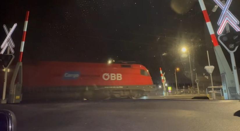 Nyitott sorompónál halad át a tehervonat a Budapest-Belgrád-vonalon – videó